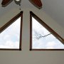 TRIANGLE WINDOWS WITH FLUTED OAK CASING AND CARVED WALNUT CORNER BLOCKS